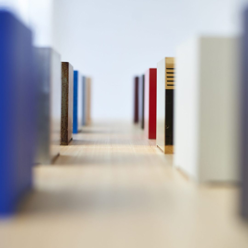 Alignement de plusieurs PC KUBB aux couleurs et finitions variées sur une table, illustrant la diversité du design.